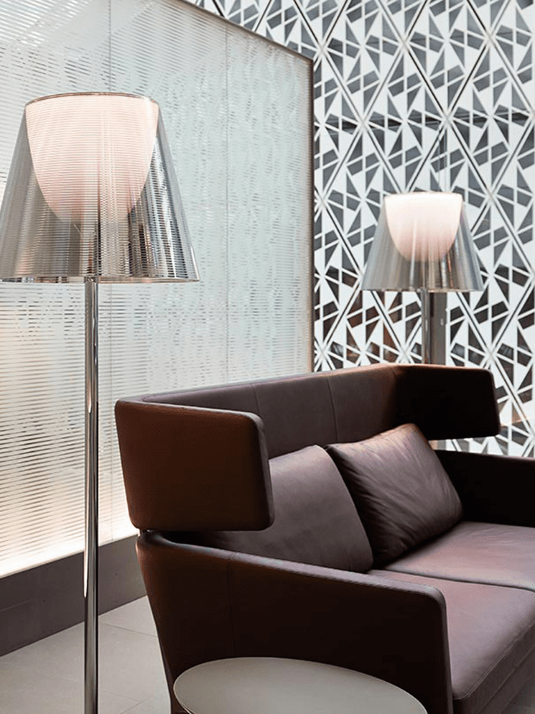Two reflective-shade floor lamps in a seating area