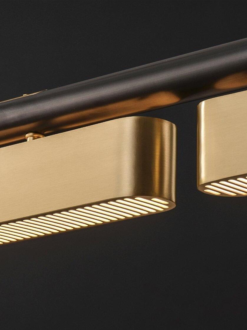 Close-up of rounded Colt brass-module ends and glowing underside slots below the black rail