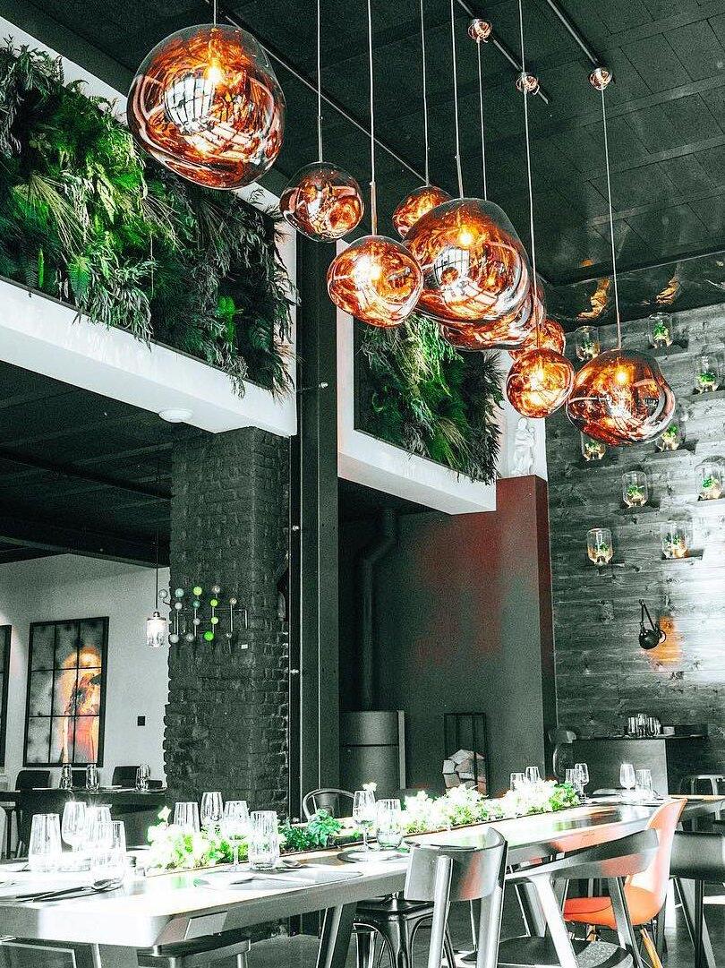 Several illuminated shades above a long dining table