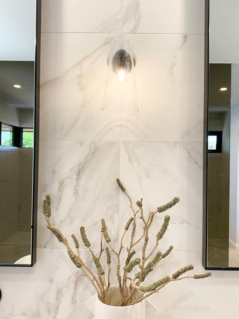 Small conical light on a marble-patterned wall