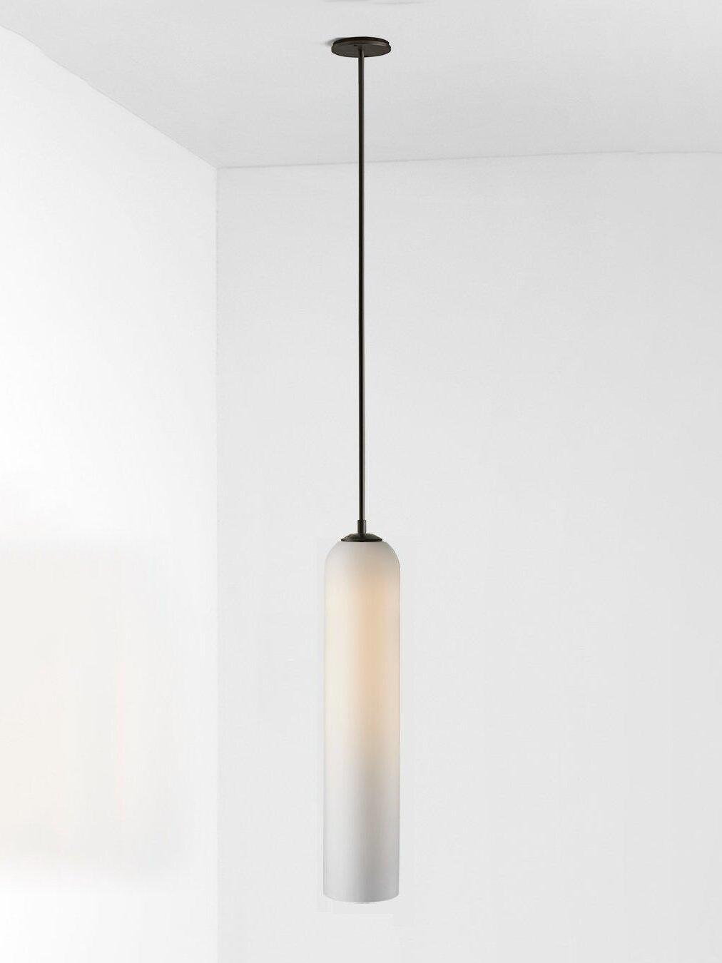 Glossy white glass Long Tube pendant with black straight rod and round canopy, shown with a pale warm glow