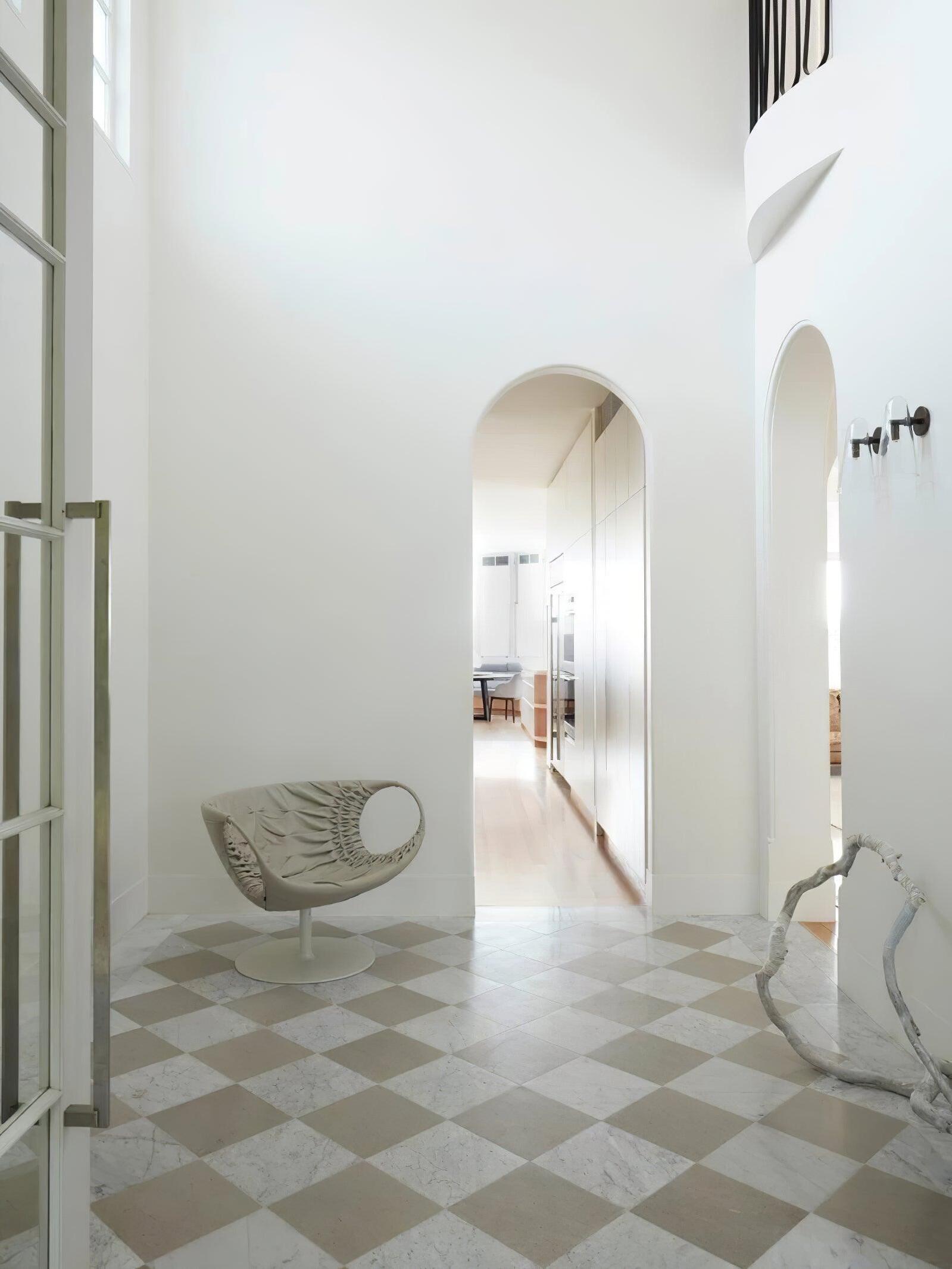 Small wall light along a corridor with an arched doorway
