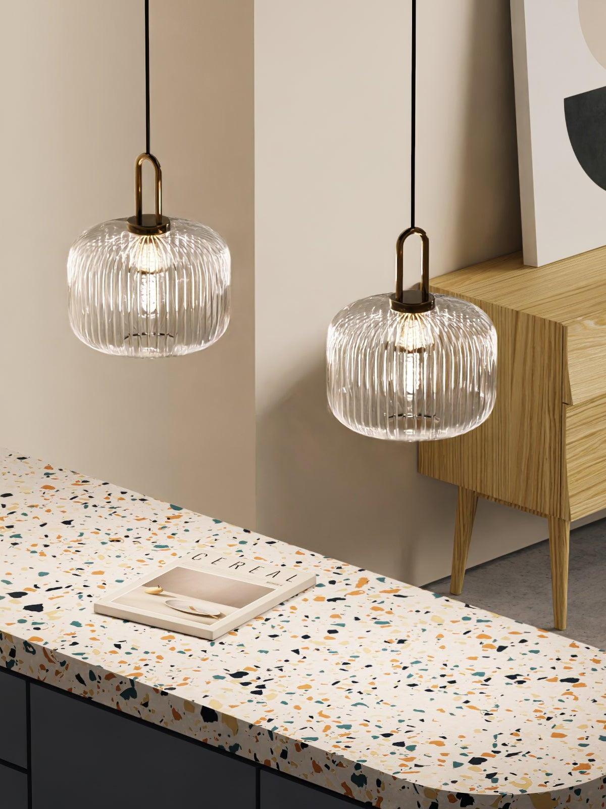 Two clear ribbed-glass pendants above a speckled counter