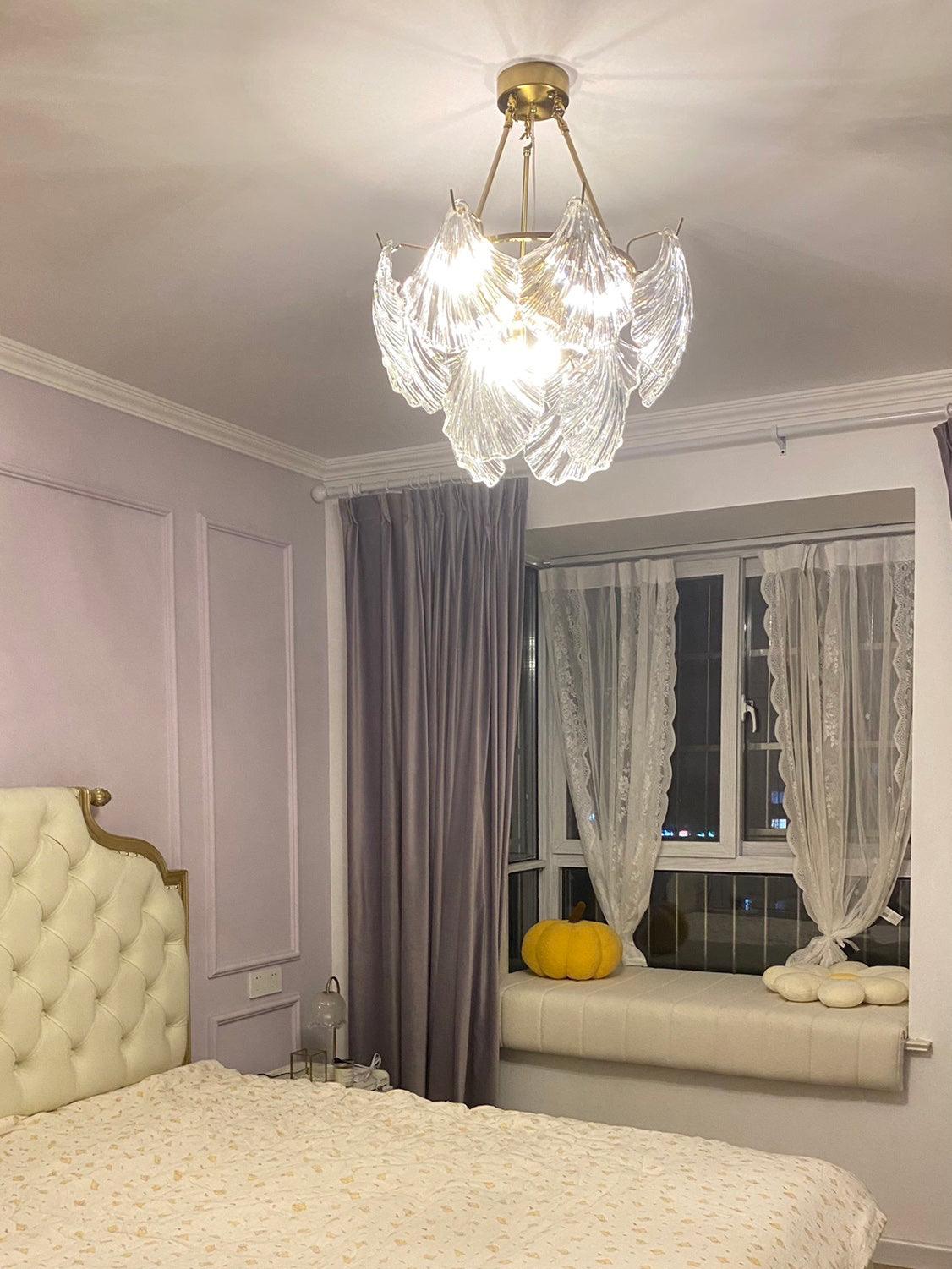 Round shell-panel fixture in a bedroom with a yellow tufted headboard and gray curtains