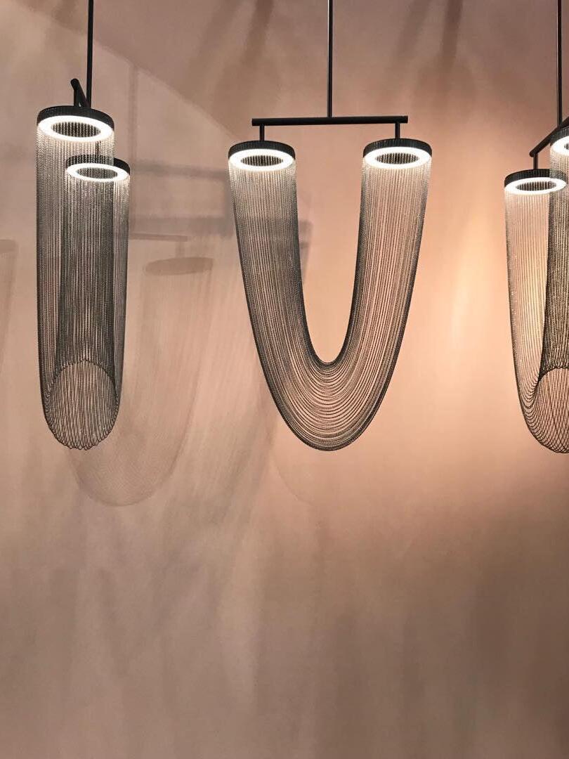 Dark chain fixtures with illuminated upper rings on display