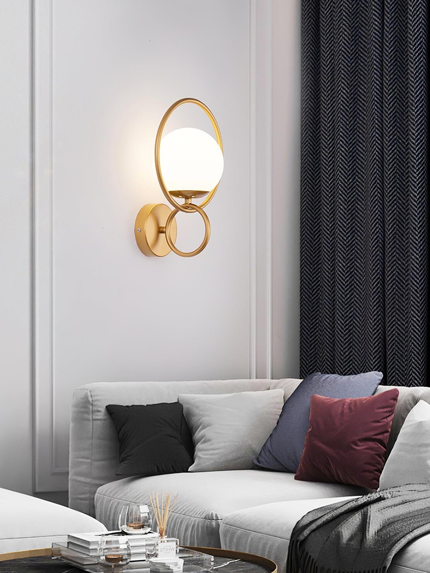 Gold oval ring globe sconce over sofa