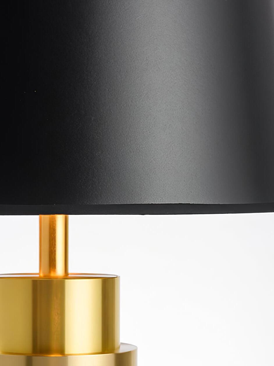 Close-up of the black shade texture and rim above the gold-tone stem and upper cylinder