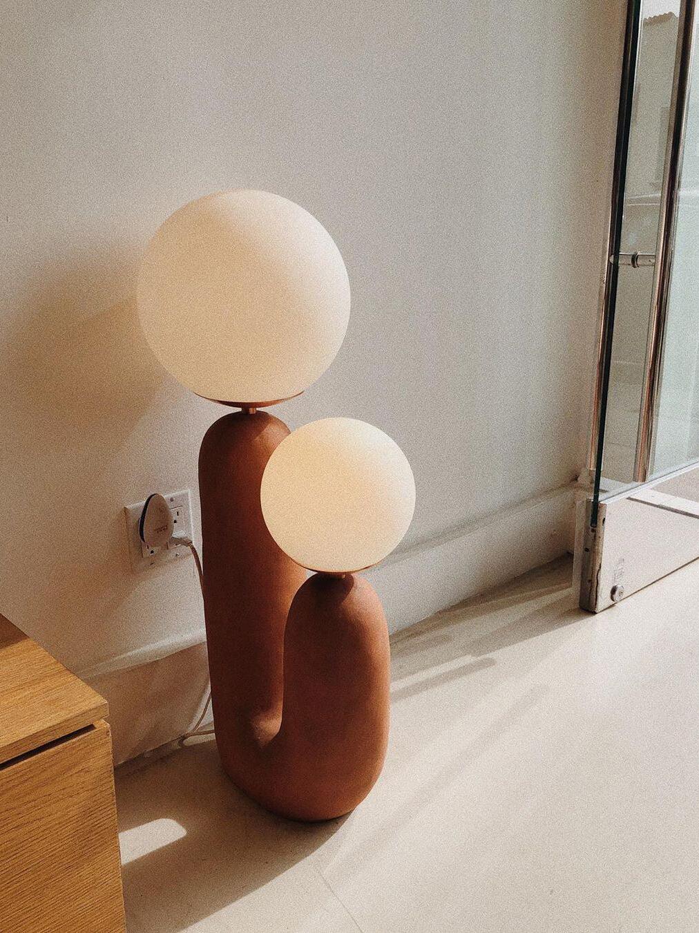 Brown double-globe lamp near a window