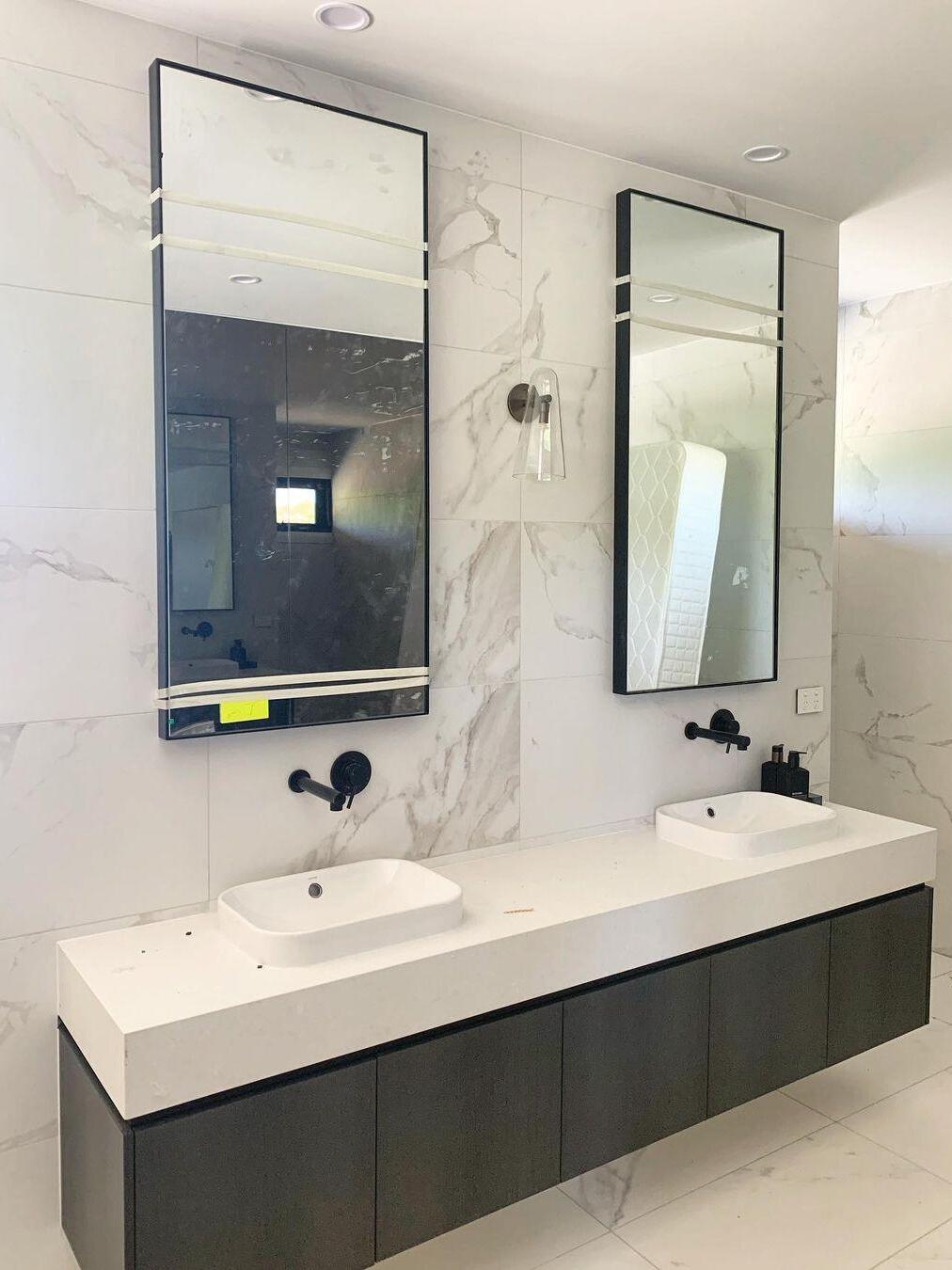 Wall lights beside two bathroom mirrors