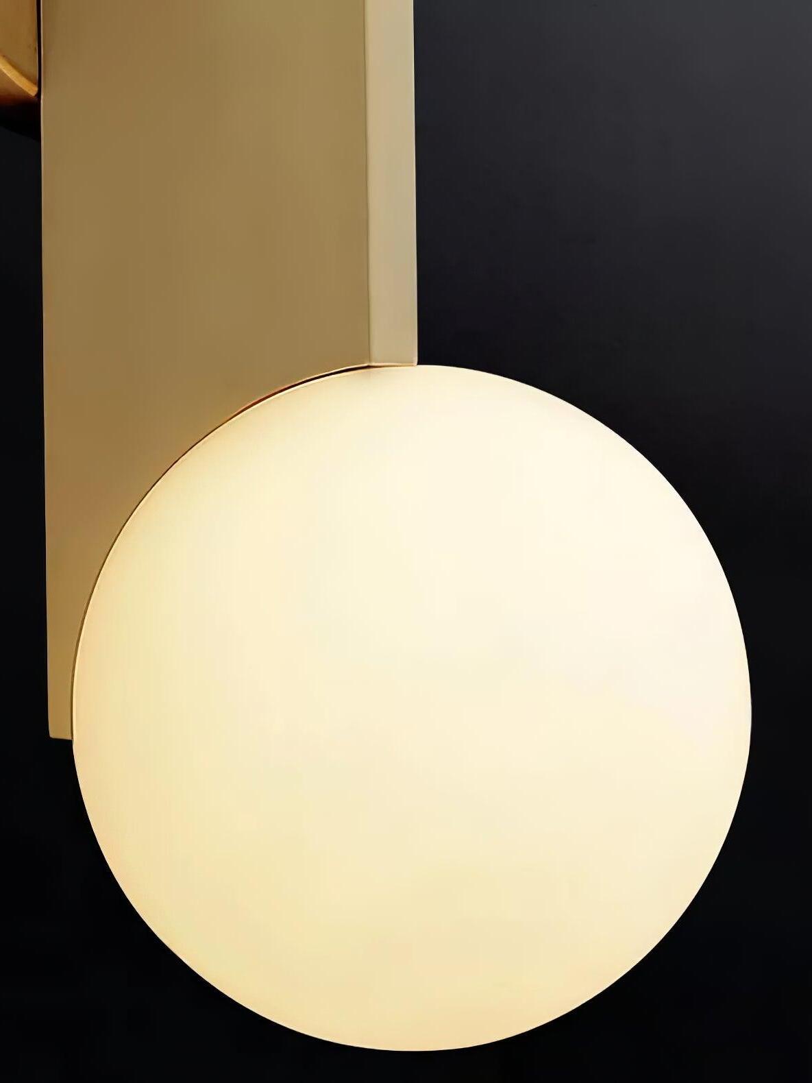 Close view of a glowing white globe below a gold-colour blade against black