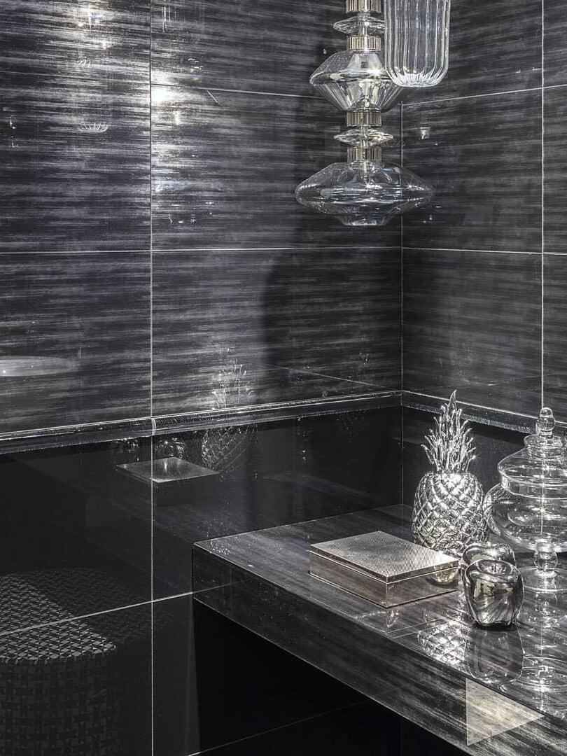 Single stacked glass pendant against dark bathroom wall