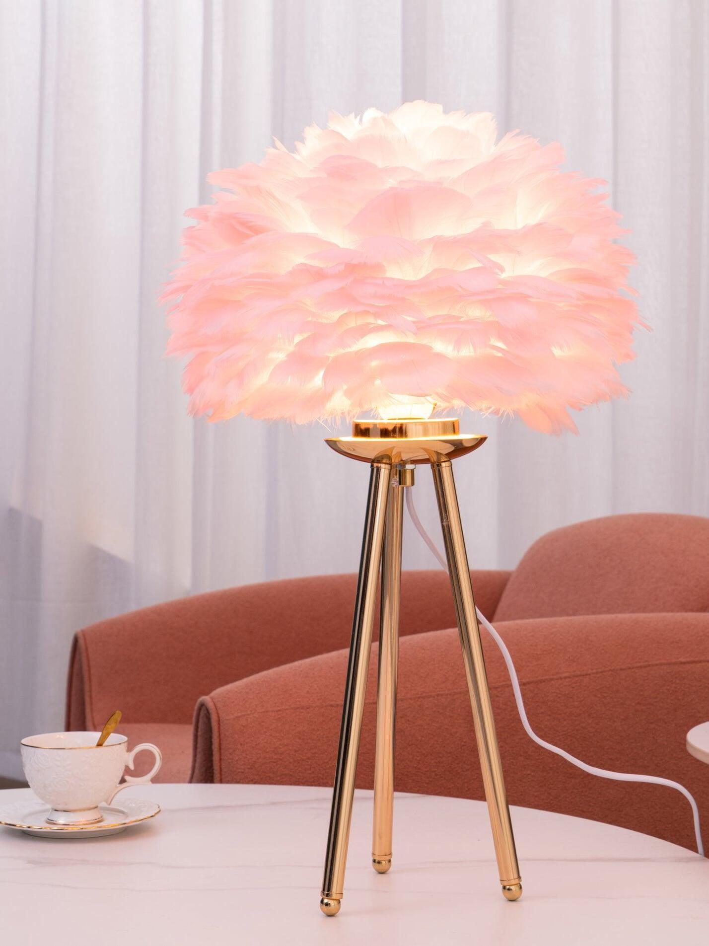 Pink feather lamp with gold tripod near sofa