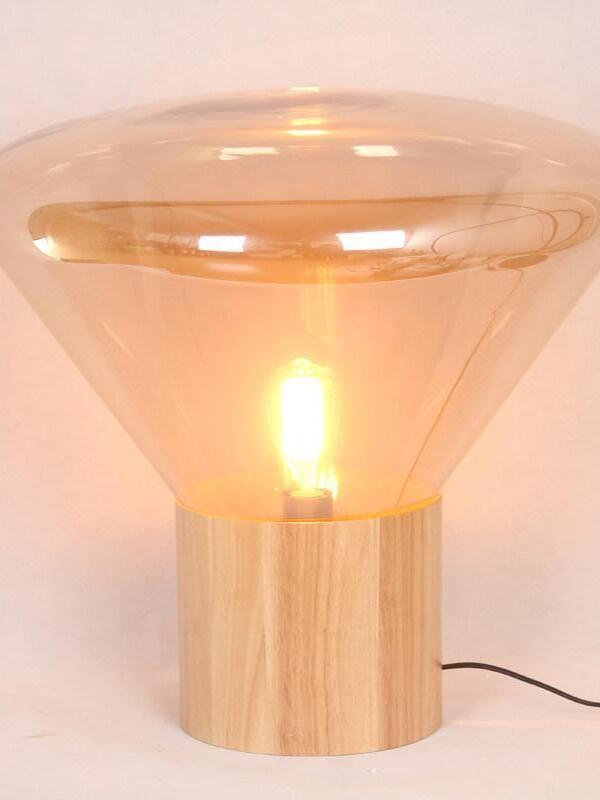Warm-lit broad flared glass lamp with wood-grain base and black cord