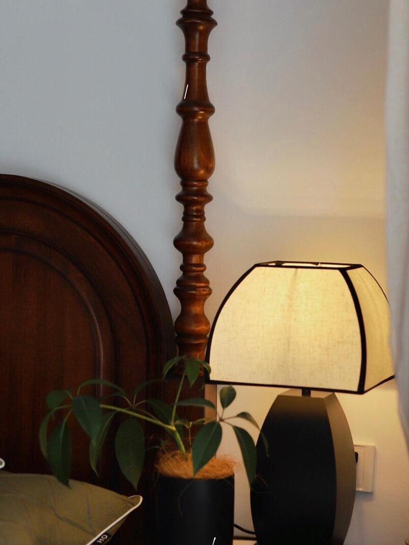 Lit Javier beside bed and wooden headboard