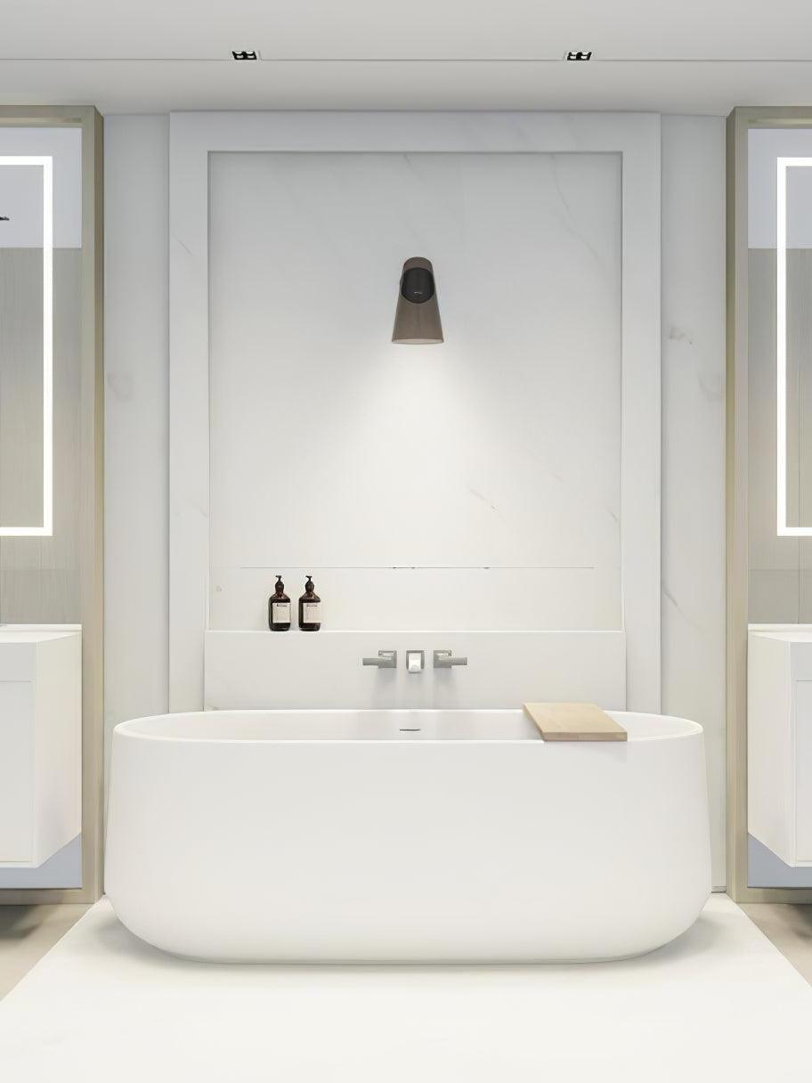 Conical wall light above a freestanding bath in a room scene