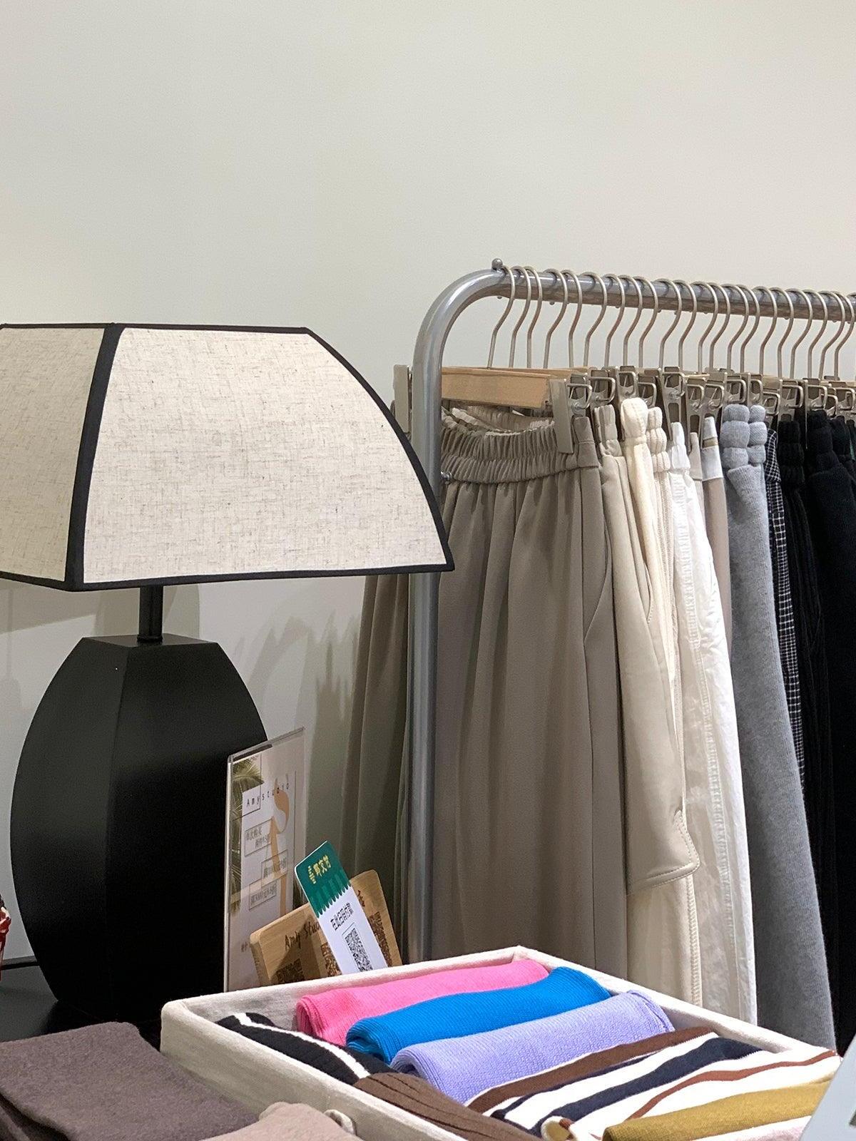 Javier lamp beside clothing rail, partly cropped