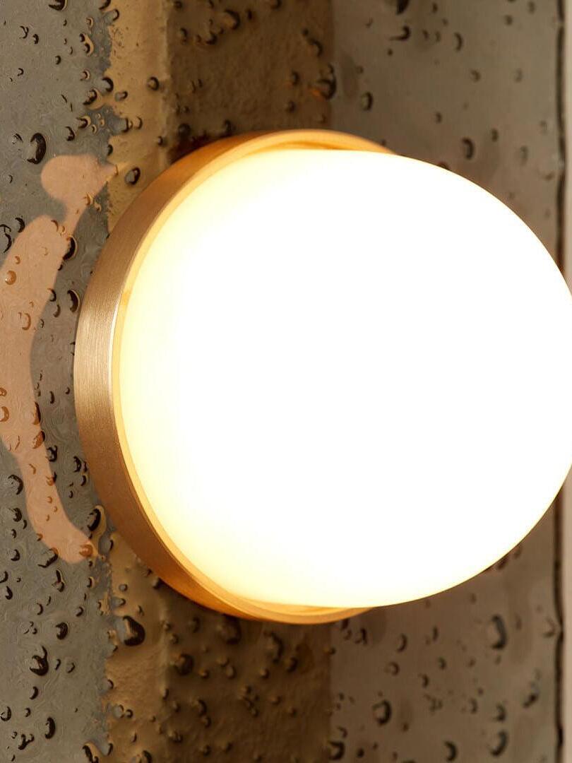 Close-up of a glowing Modulo dome with a gold-tone rim against textured grey glass