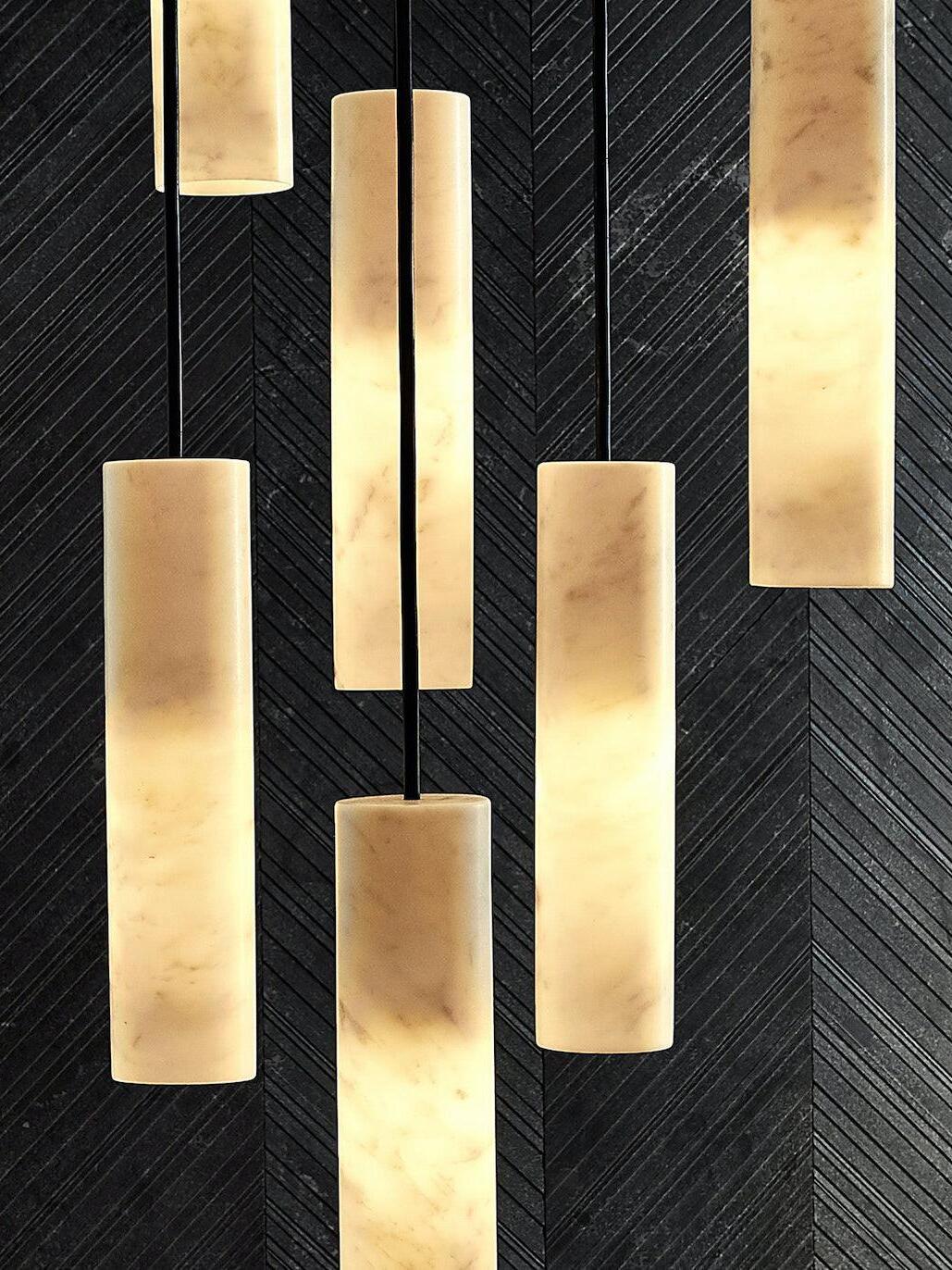 Close view of glowing Silo cylinders and dark cords against a black chevron-patterned wall