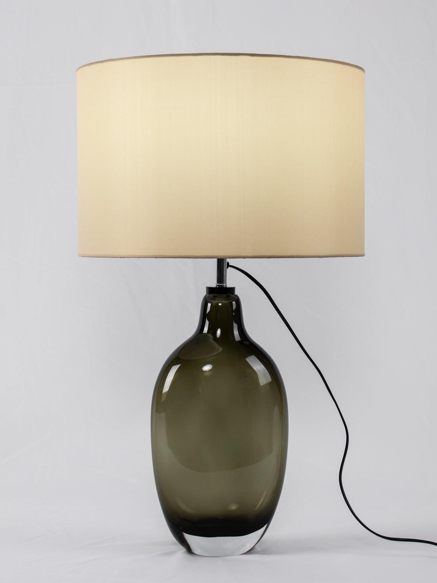 Front view of illuminated lamp with smoky base and black cord