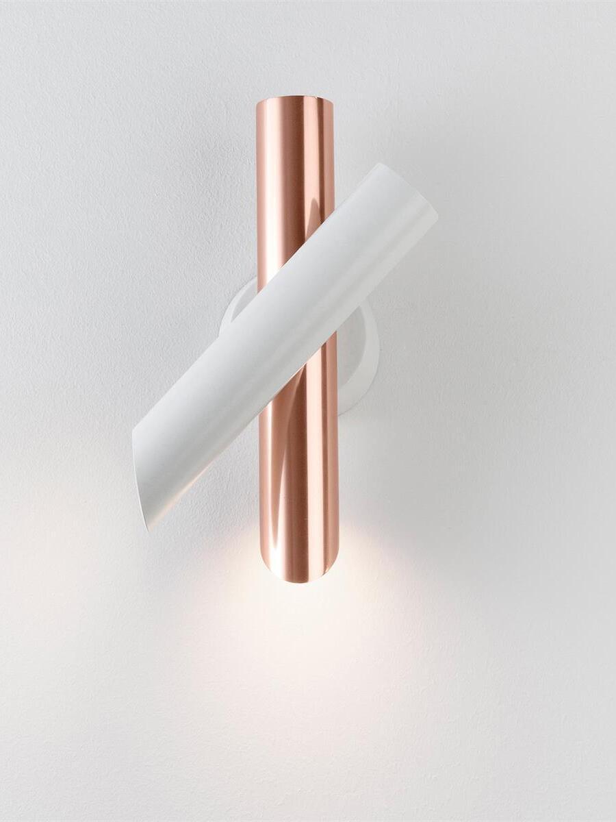 White and rose-gold wall lamp with lower light on