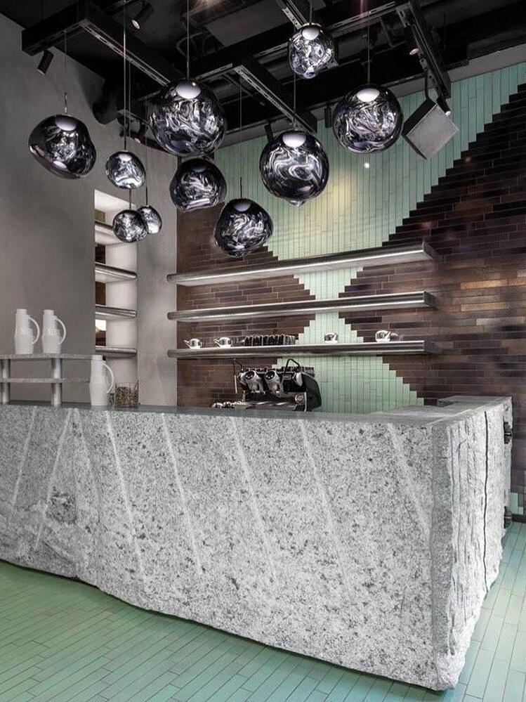 Dark reflective pendants above a bar counter
