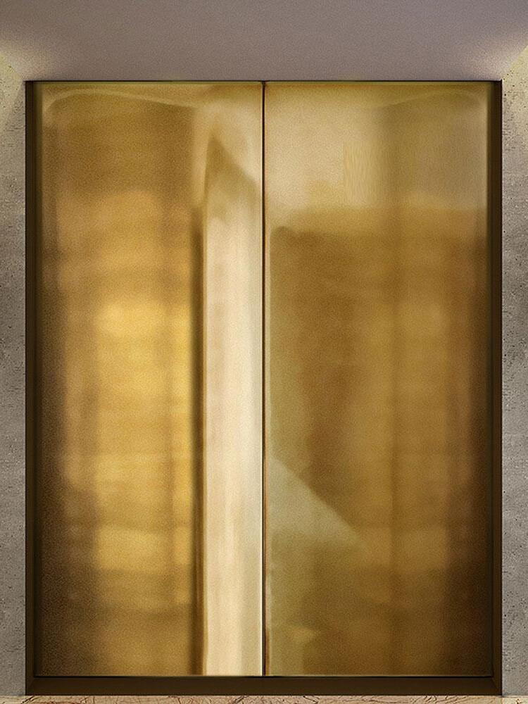 Two reflective gold-coloured rectangular door panels with dark borders beside a pale veined wall