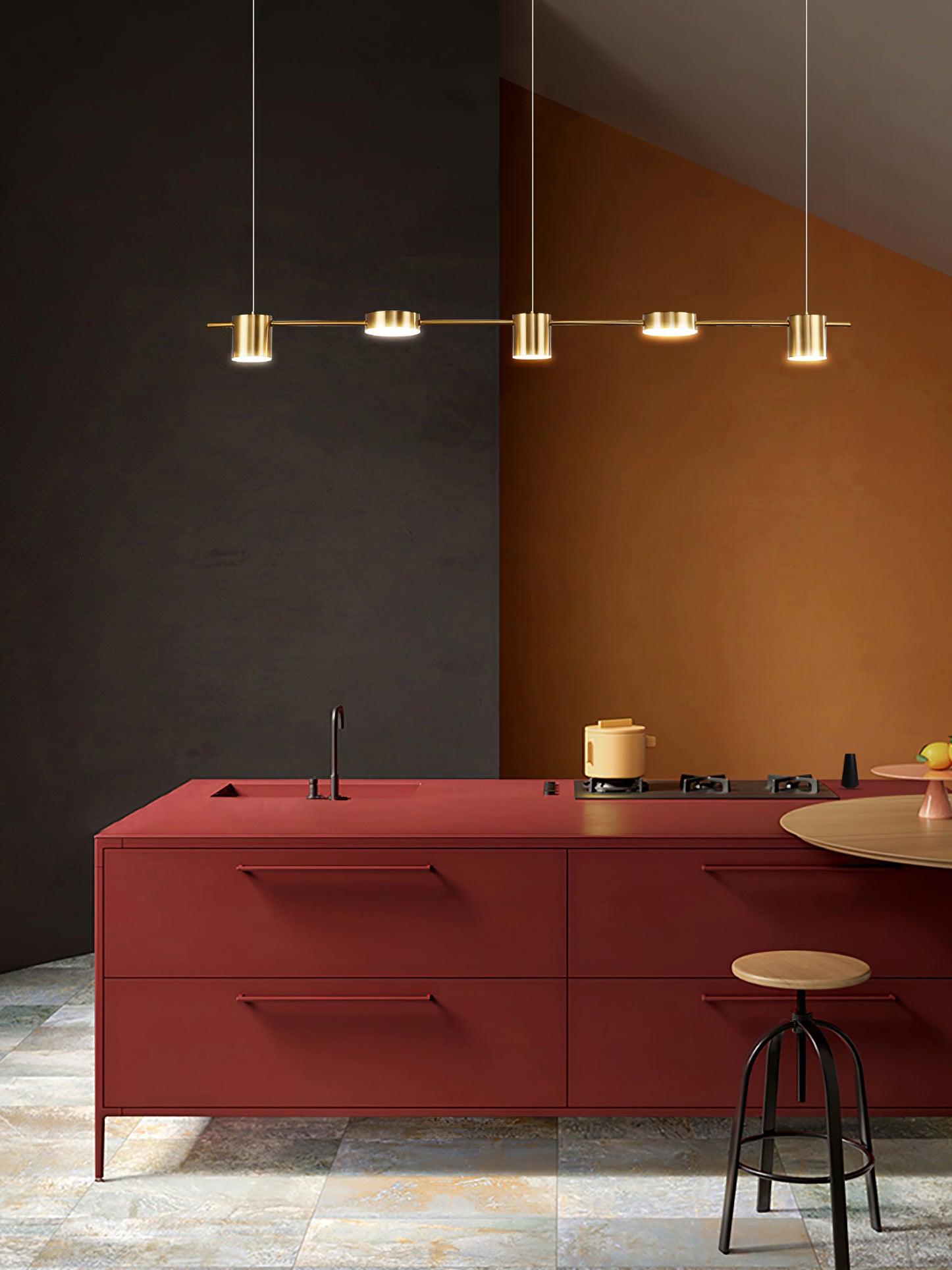 Gold linear pendant above a red kitchen counter