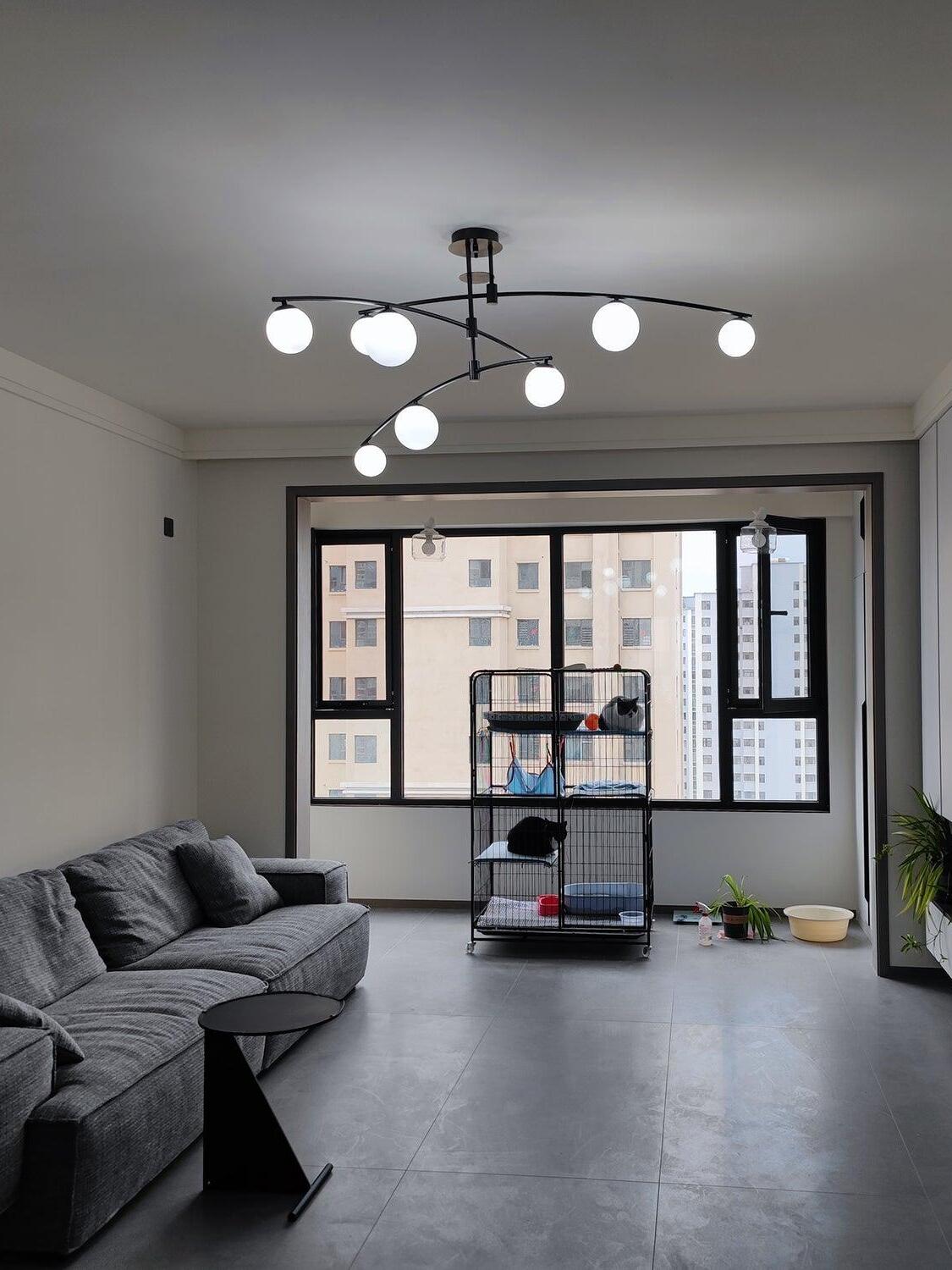 Black crossing-arm chandelier above a coffee table