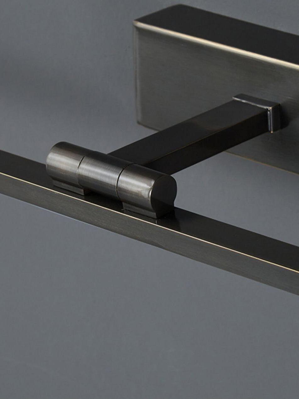Close-up of black wallplate, projecting central arm and cylindrical joint behind slim horizontal light bar