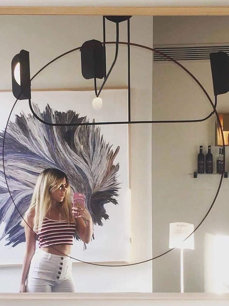 Black chandelier above a table near a large portrait