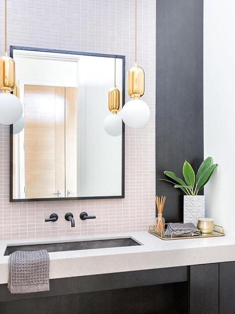Paired globe pendants beside a bathroom mirror