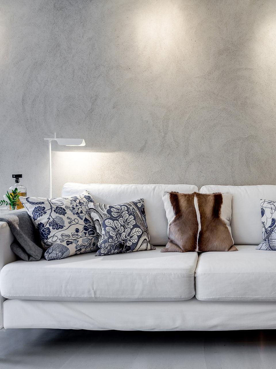 White floor lamp behind a sofa