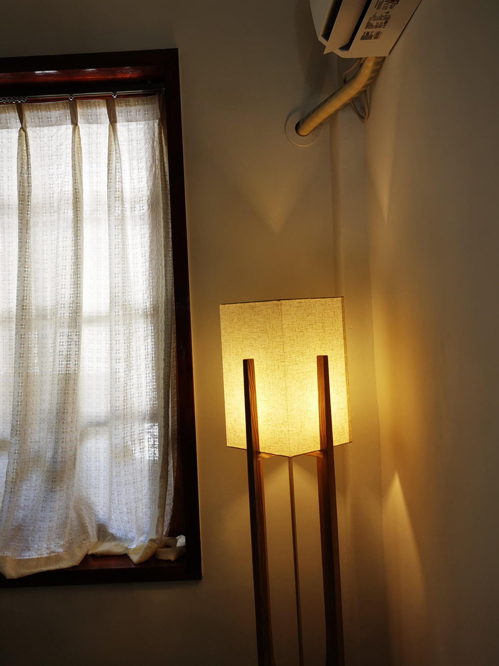 Glowing fabric shade and tall frame near curtains