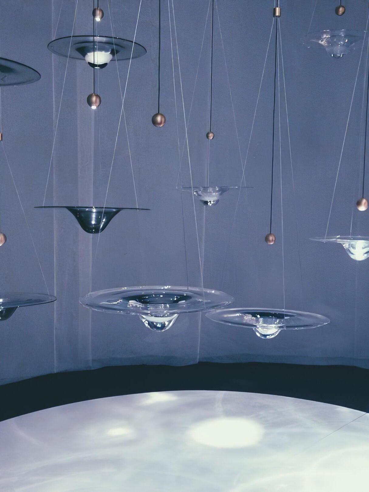 Glass disc pendant group above softly lit surface