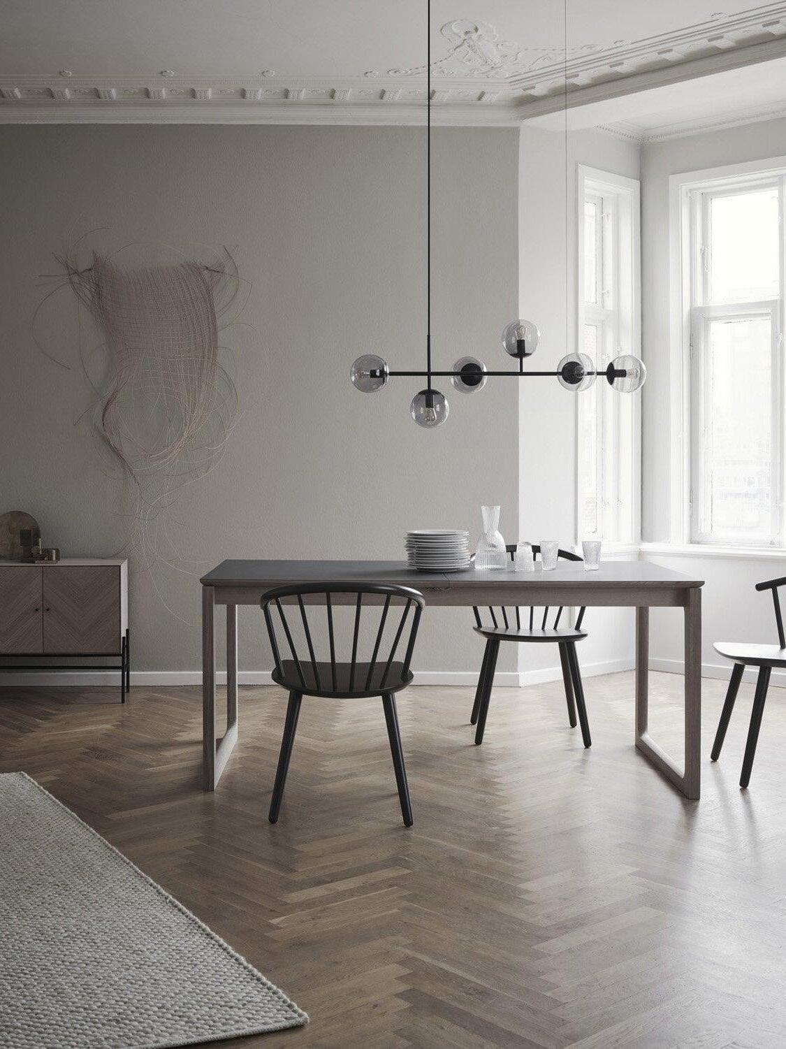 Black linear globe chandelier over a minimalist table