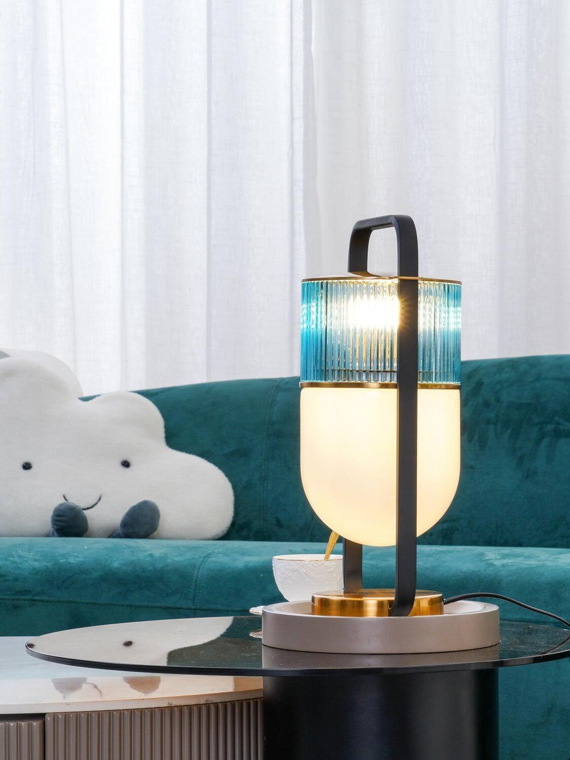 Rear view of an illuminated Xi lamp with a dark upright crossing the glass shades beside a sofa