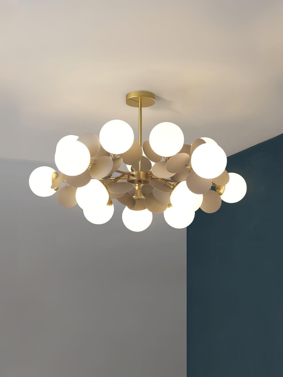 Wide gold chandelier with fifteen white globes and grey leaf-like discs