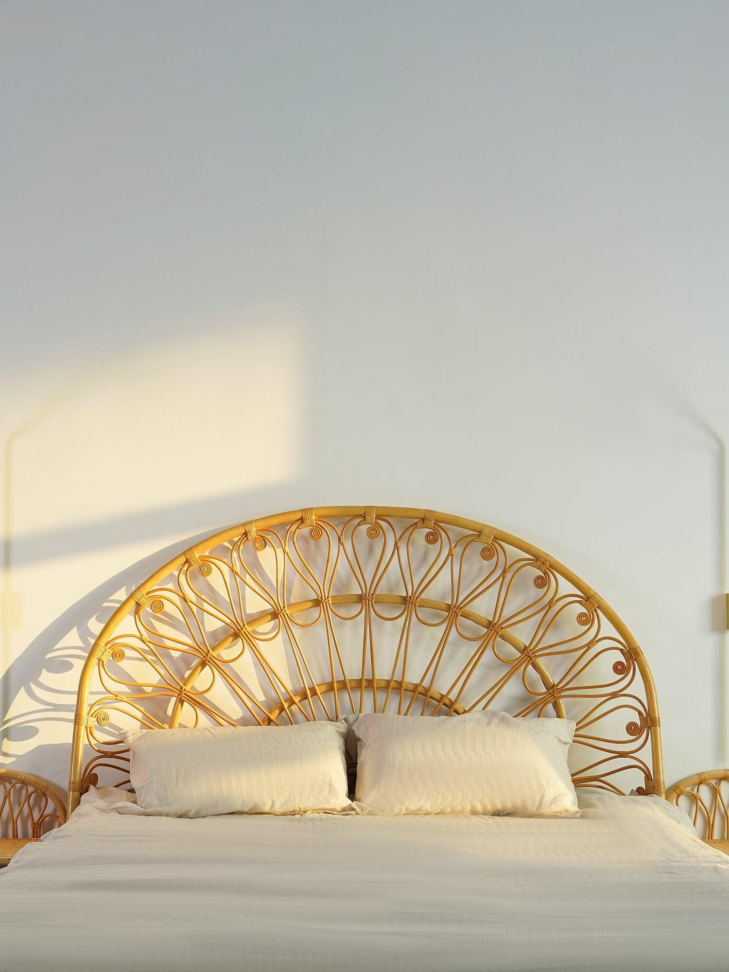 Golden sconce near a rounded woven headboard