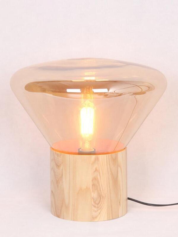 Amber-tinted flared glass shade with lit bulb and wood-grain base