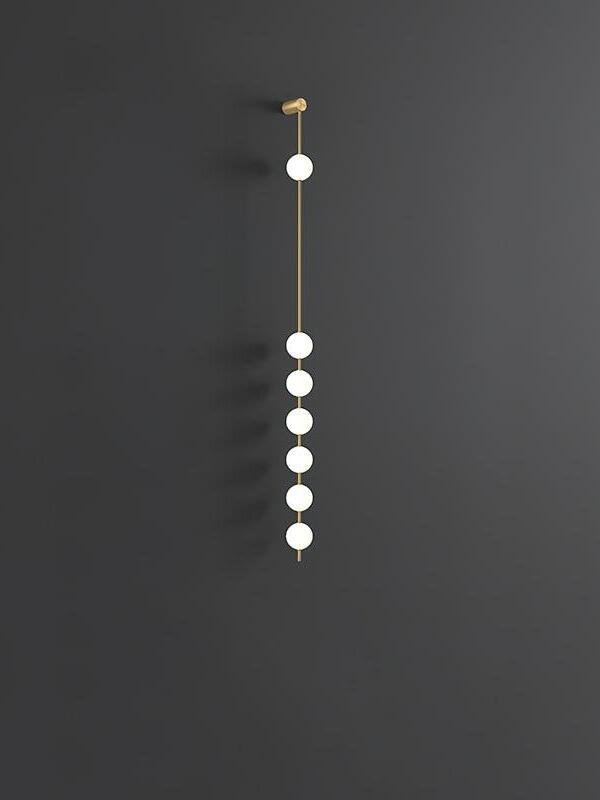 Seven-globe gold-colour wall lamp framed at smaller scale against dark grey