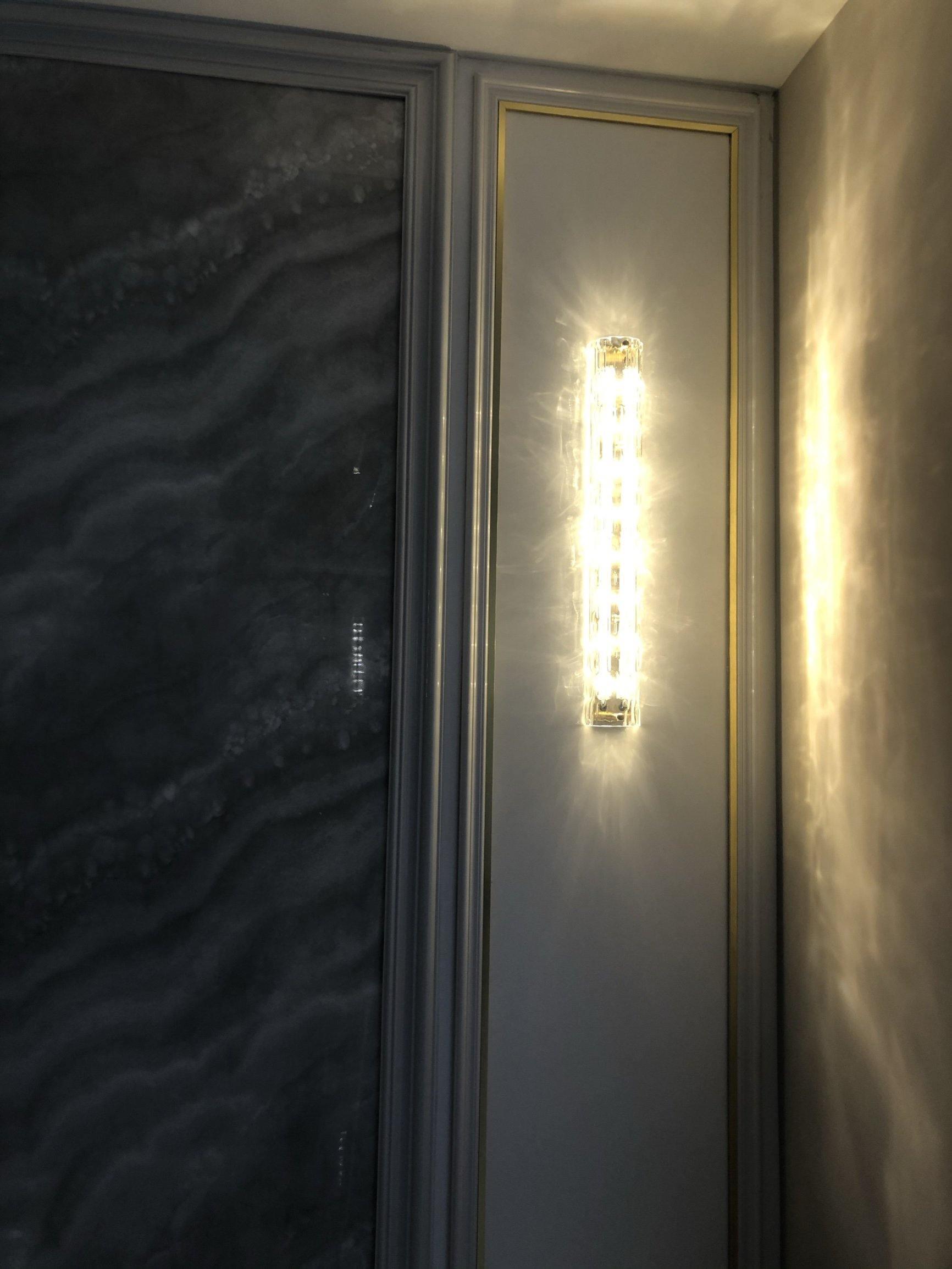 Wider view of glass wall bar beside dark veined wall