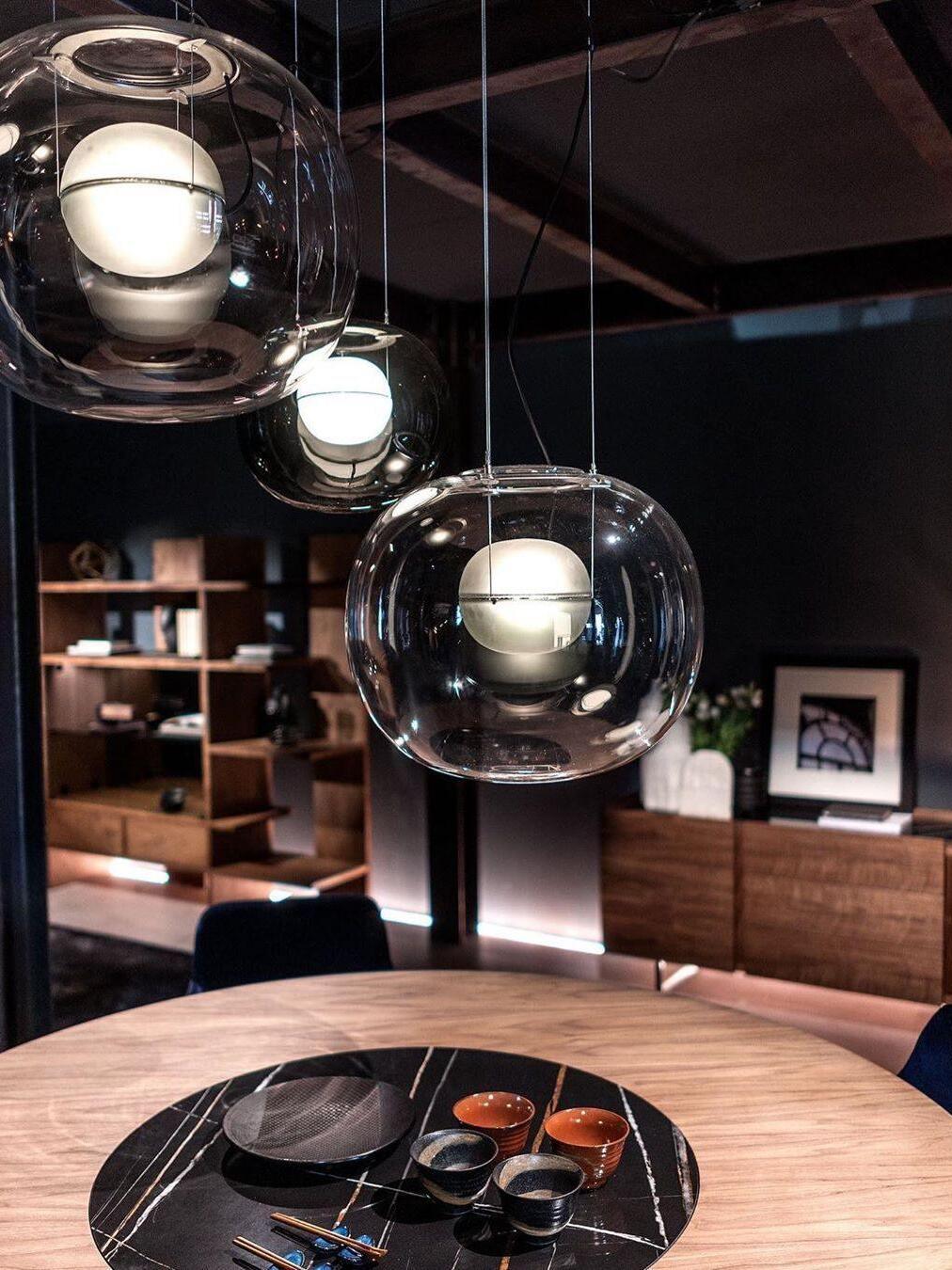 Glass globe pendants above a round wooden table