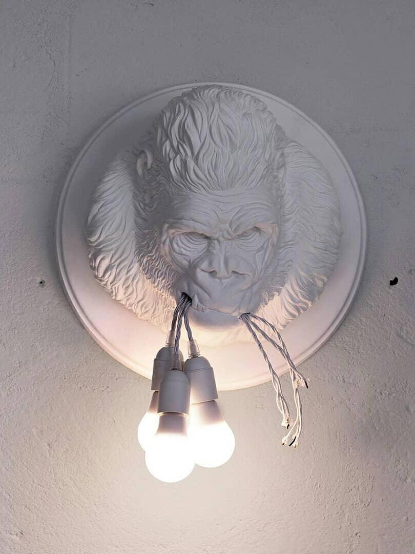 Frontal white gorilla face on round backing with glowing round bulbs