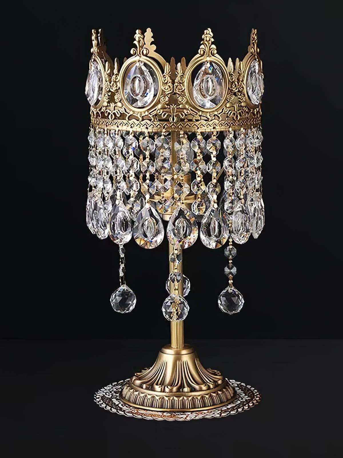 Open-top crown crystal table lamp with long lower drop chains, photographed against a black background.