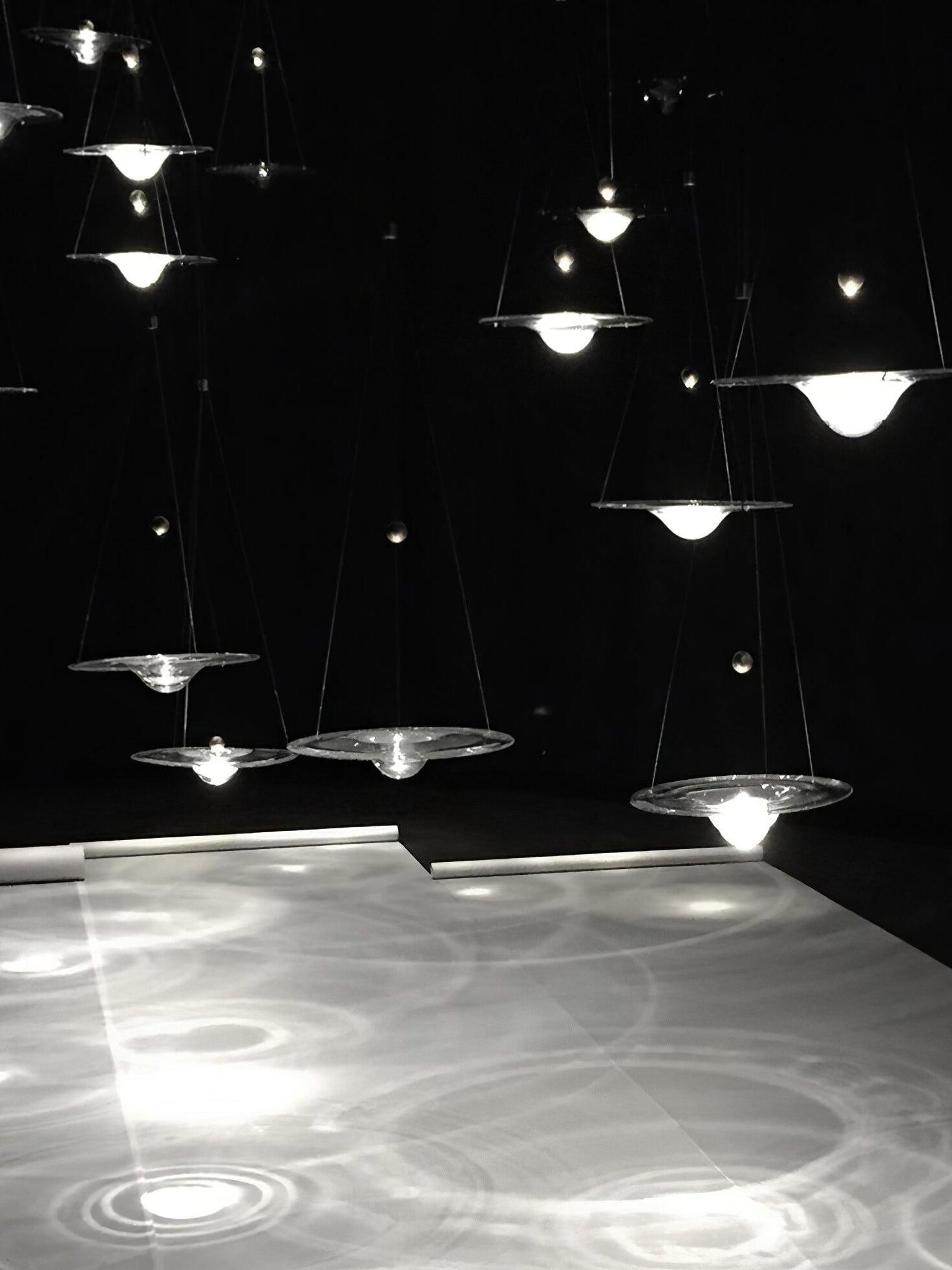 Lit glass discs casting circular pools on floor