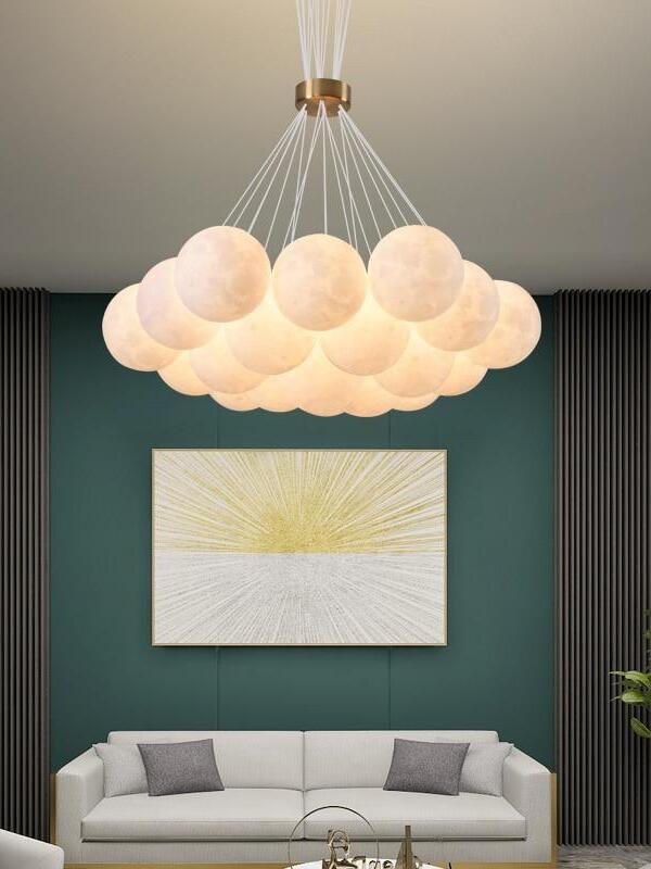 Large illuminated moon-sphere pendant above a sofa