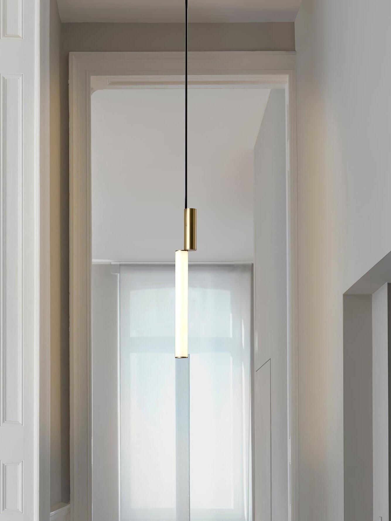 Single gold-top tube pendant in high doorway