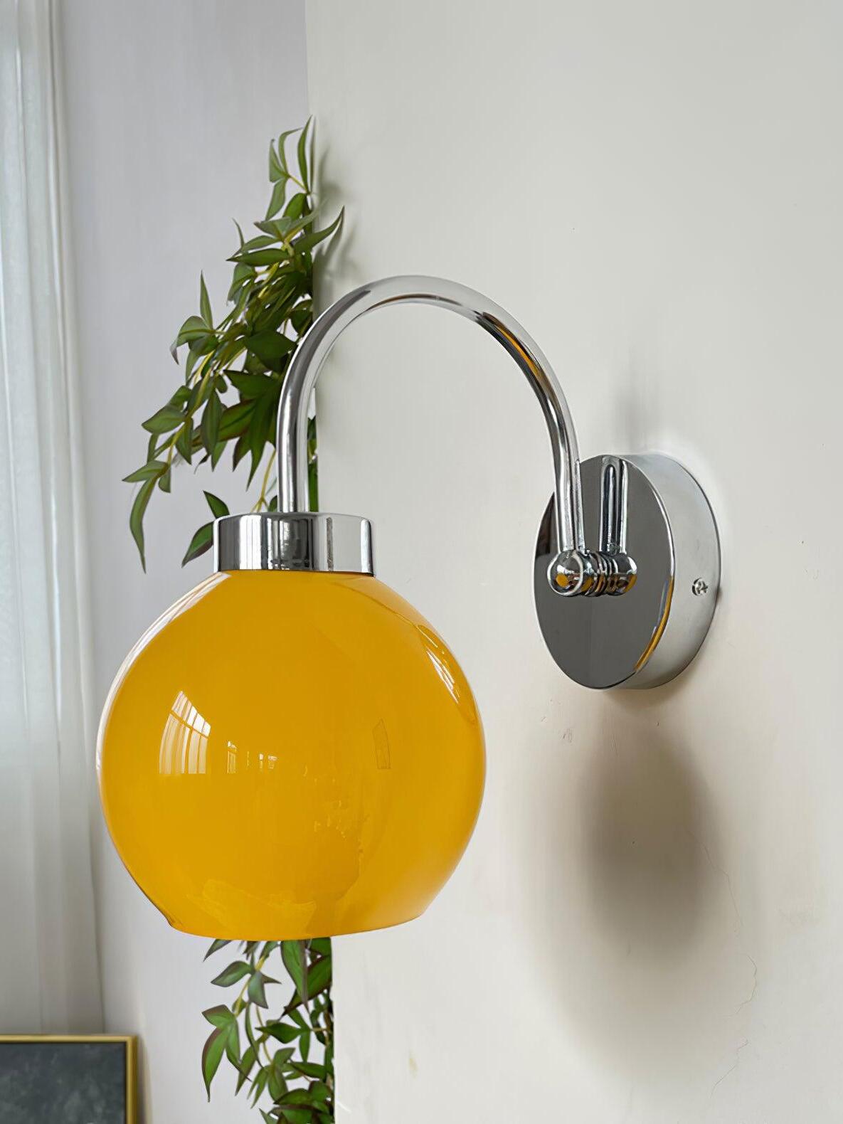 Orange glass globe below arch beside bright window and trailing plant