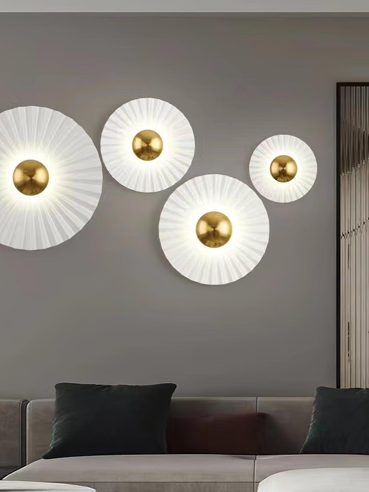 Four white pleated wall lights above a sofa