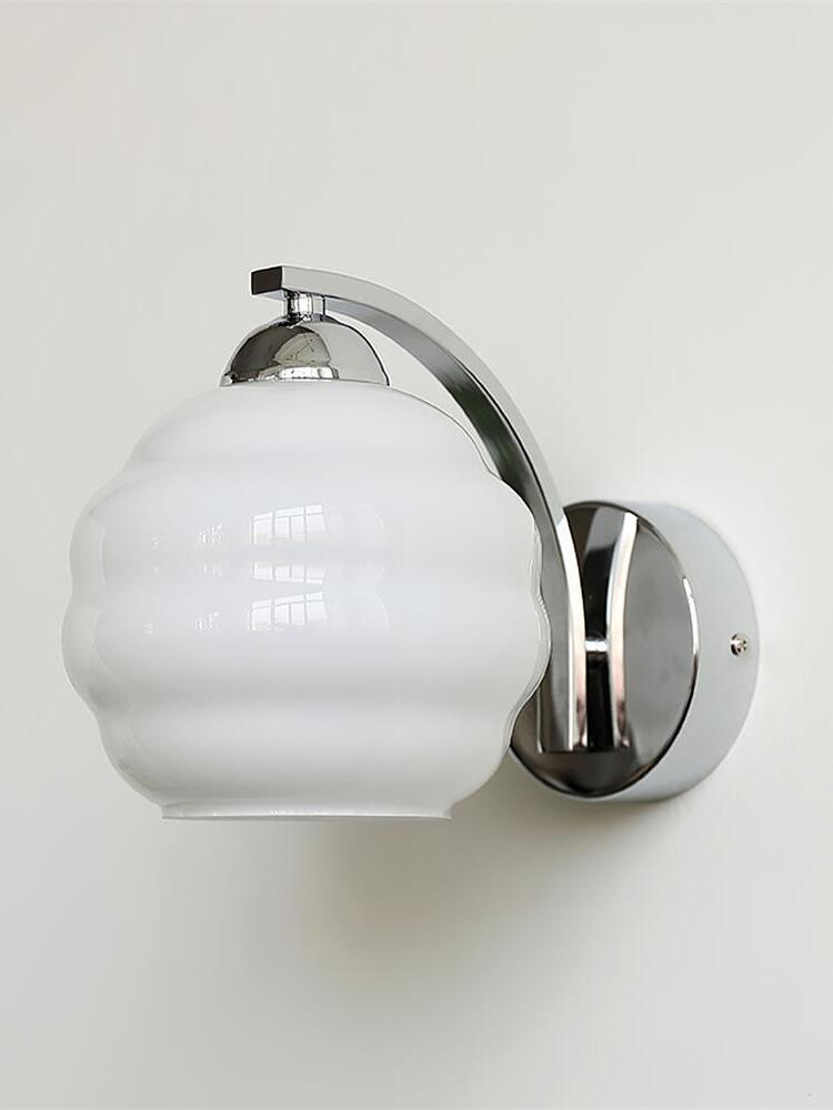 Unlit white glass shade with broad rounded contours and polished chrome arm and round wall plate on the right